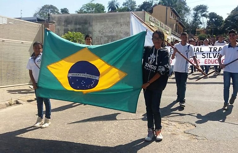 Alunos da Escola Estadual Trajano Procópio seguram bandeira durante desfile